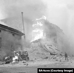 Shattered buildings and a car burn in Helsinki after an air raid on the opening day of the Winter War.