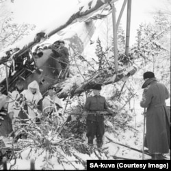A downed Soviet plane being picked apart by a Finnish patrol.