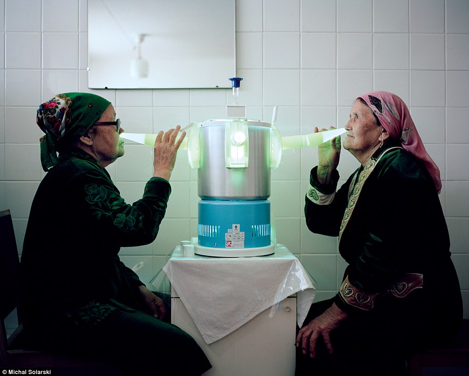 Kyrgyzstan: Two women use ultraviolet light-emitting sterilisation lamps in their noses to  kill bacteria, viruses and fungi
