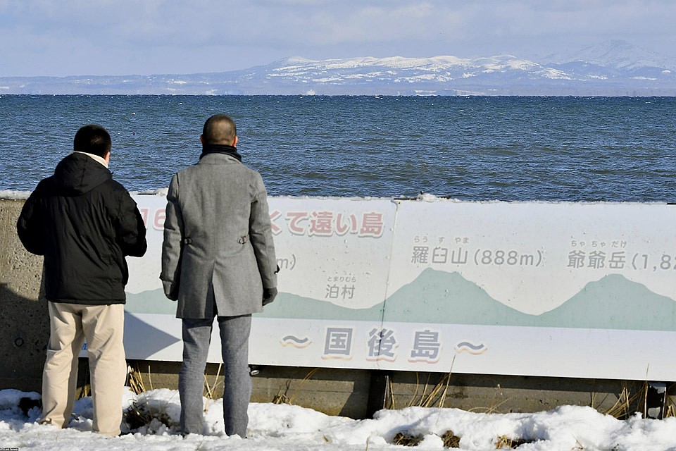 Японские туристы смотрят с территории острова Хоккайдо на российский остров Кунашир, входящий в южные Курилы. Фото: EAST NEWS