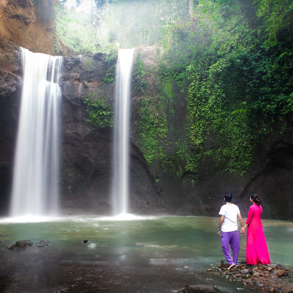 Couple standing at Tibumana waterfall near Ubud in BAli