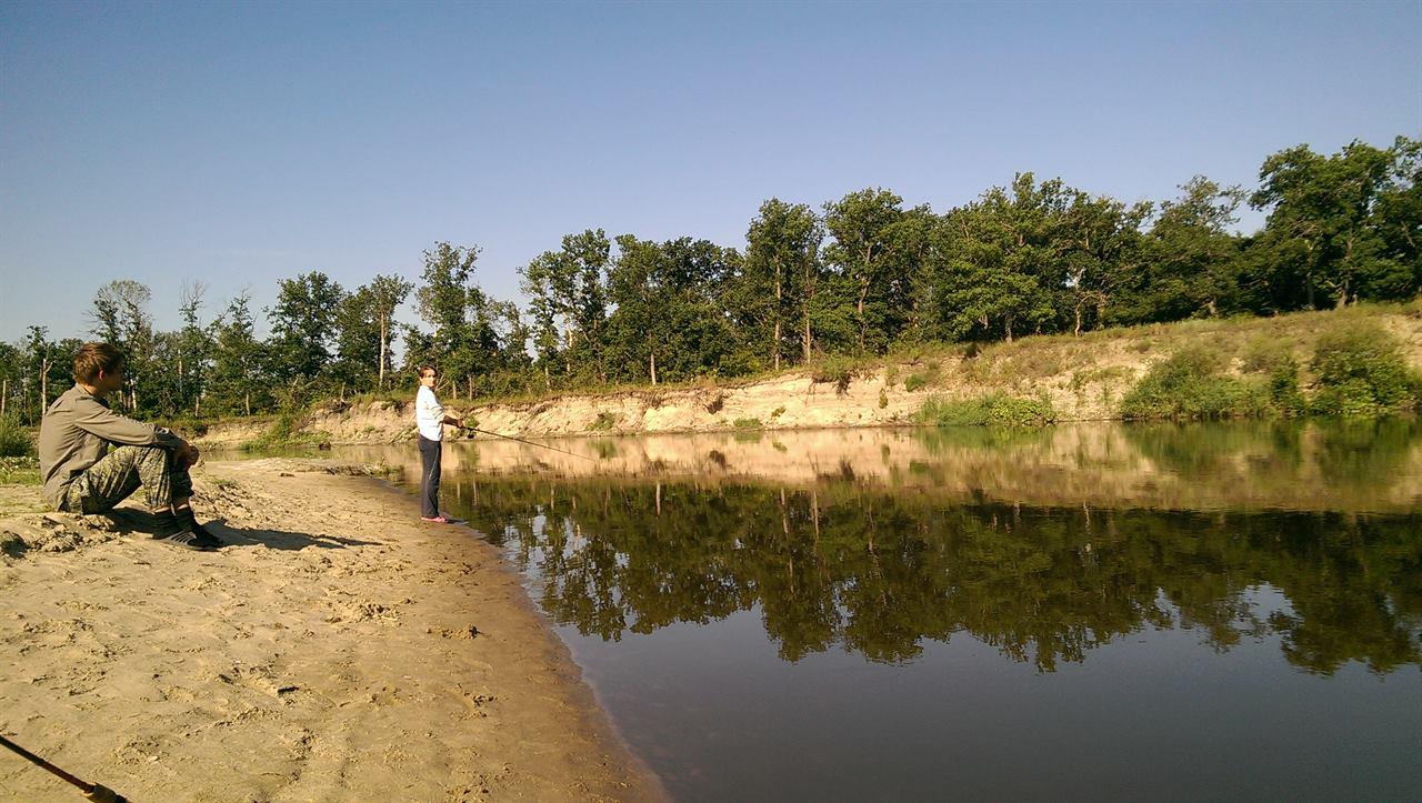 Девушка рыбачит на реке
