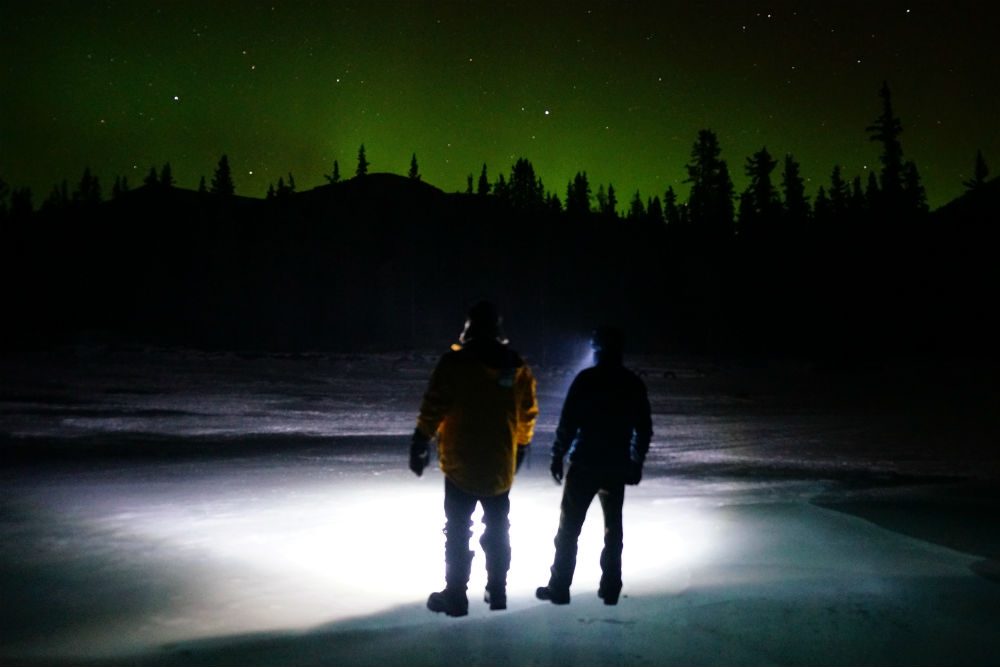 two people watching the northern lights in british columbia canada