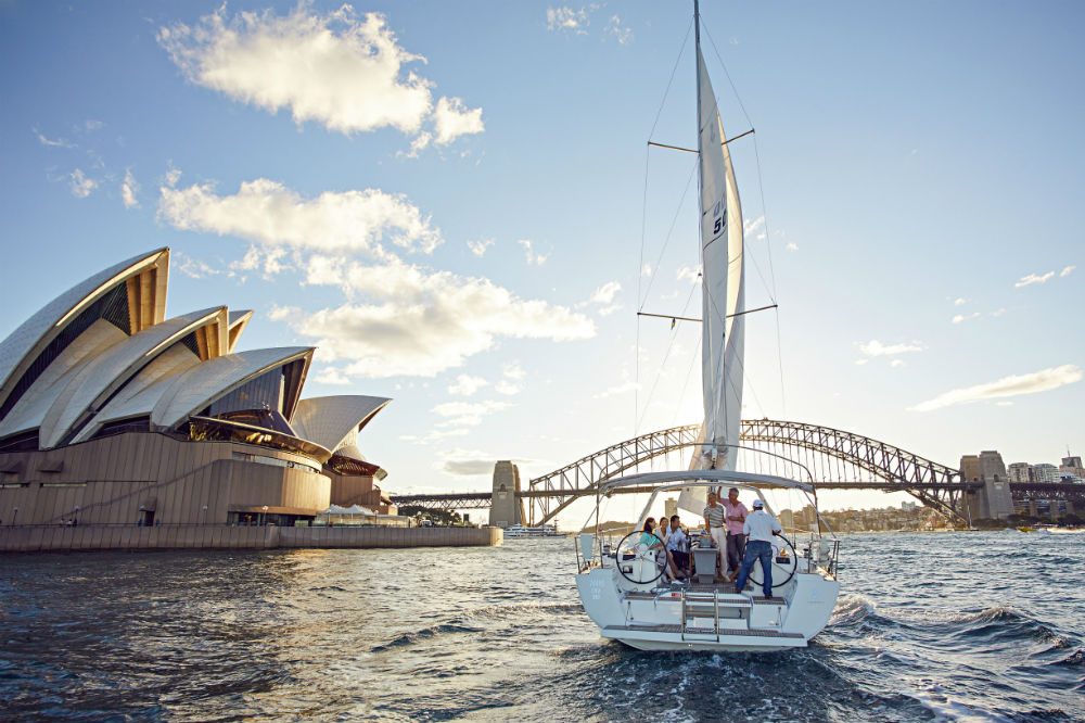boat sailing in water on Sydney Harbour Australia with famous bridge in background